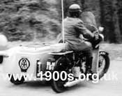 A man from the AA (Automobile Association) in the 1940s or 1950s, driving around by motor bike with sidecar to offer help to motoring AA members in difficulty.