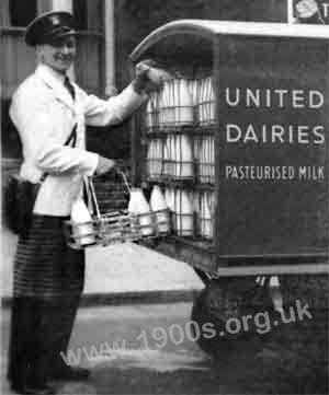 Milkman's uniform, mid-20th century: black peaked hat, white overall, leather shoulder coin bag and the protective apron.
