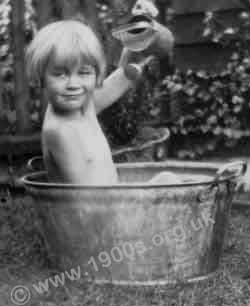 Child playing in a tin bath in 1930s London