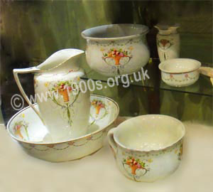 Decorative china wash set: matching wash bowl, hot water jug, slop bowl, soap dish, chamber pot and shaving jug as used in and before the early 1900s before there was running hot water.
