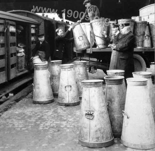 Loading milk churns onto a train, about 1920