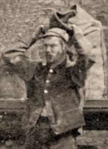 Coalman wearing traditional hat and coat carrying a sack of coal