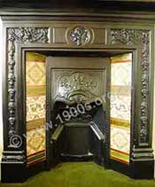 A typical black Edwardian fireplace with decorative tiles on either side