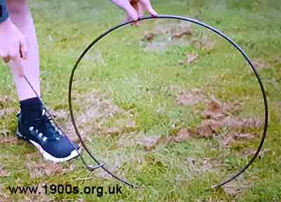 iron hoop being rolled by a modern expert with the rod close to the ground