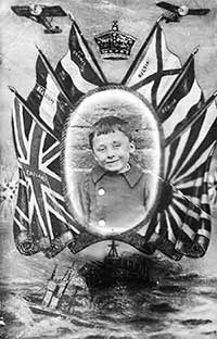 World War One propaganda photograph of a boy, showing him framed with the king's crown, the British flag, flags of the allies, fighter planes and a warship.
